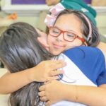 alunas especial abraça colega de escola