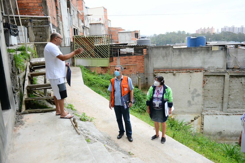 esquipe da defesa civil orienta morador sobre chuvas