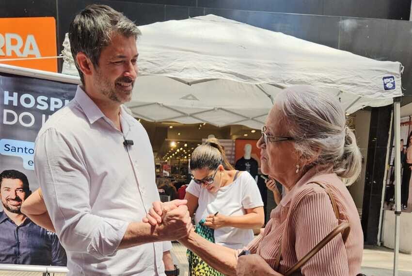 Eduardo Leite falando com mulher na rua